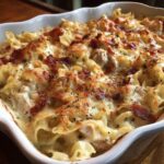 Close-up of a bubbling Chicken Bacon Ranch Casserole topped with crispy bacon and melted cheese.