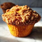Close-up of a perfectly baked coffee cake muffin with a generous streusel topping.