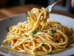 A fork twirls a generous portion of creamy lemon pasta, garnished with fresh parsley and grated cheese.