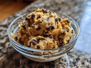 A close-up of a bowl filled with delicious high protein cookie dough and chocolate chips.