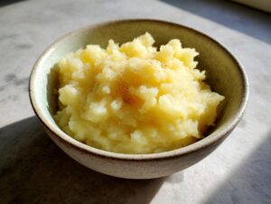 A close-up of fluffy homemade applesauce in a rustic bowl, sprinkled with cinnamon.