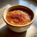 A rustic bowl filled with delicious homemade applesauce, topped with a dusting of cinnamon.