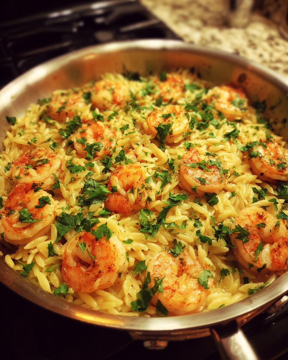 Close-up of shrimp orzo pasta in a lemon garlic sauce, garnished with fresh parsley.