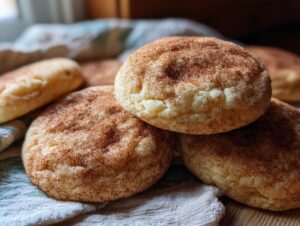 A close-up of freshly baked apple cider snickerdoodle cookies, dusted with cinnamon sugar.