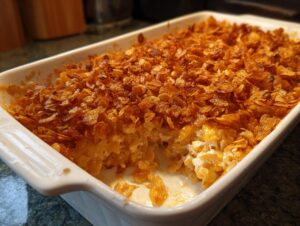 A close-up of a freshly baked chicken hashbrown casserole with a crispy, golden-brown topping.