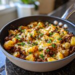 Close-up of a creamy meat potato skillet topped with melted cheese and fresh parsley.