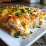 A slice of French Onion Chicken Rice Casserole topped with melted cheese and fresh parsley.
