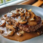 A juicy hamburger steak smothered in rich mushroom gravy with sliced mushrooms and onions.