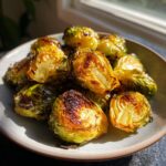 Close-up of a bowl filled with perfectly roasted Brussels sprouts, showcasing their caramelized edges and tender interiors.