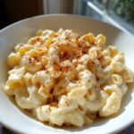 A close-up of creamy stovetop mac and cheese in a white bowl, sprinkled with paprika.