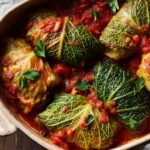 Close-up of delicious stuffed cabbage rolls nestled in a rich tomato sauce, garnished with fresh parsley.
