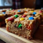 Close-up of a Christmas cookie bar topped with colorful M&Ms and chocolate chips.
