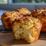 Close-up of a fluffy garlic rosemary focaccia muffin with a bite taken out, showing its airy crumb.