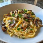A close-up of creamy Leek and Mushroom Gruyere Pasta, garnished with fresh parsley.