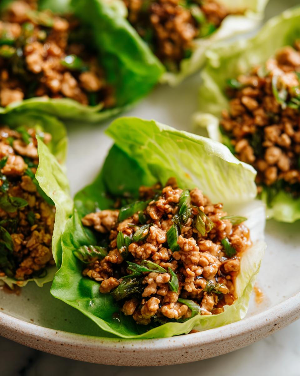 Close-up of delicious chicken lettuce wraps filled with savory ground chicken mixture and green onions.