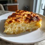 Two slices of creamy, layered scalloped potatoes with a deeply browned, cheesy crust served on a white plate.