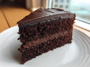 Close-up of a moist, dark chocolate layer cake slice, a perfect example of a Capricorn cake flavor.