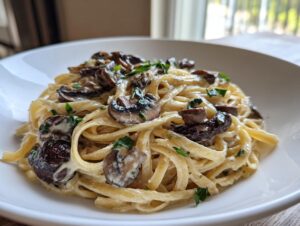 Close-up of creamy fettuccine mushroom pasta topped with sautéed mushrooms and fresh parsley.