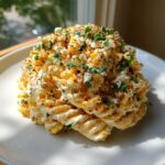 A mound of creamy street corn pasta salad topped with cotija cheese, chili powder, and cilantro.