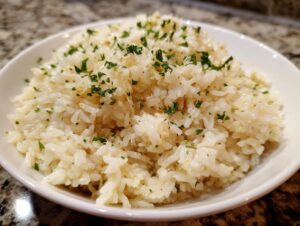 Close-up of fluffy white rice tossed in butter and topped with fresh parsley, our amazing garlic butter rice.