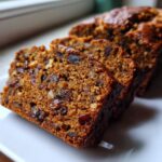 Close-up of moist date nut bread slices showing rich texture filled with dates and walnuts.