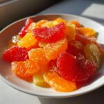 Close-up of vibrant orange and red citrus segments in a white bowl, perfect for a fresh citrus salad.