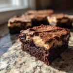 A close-up of a rich, fudgy banana bread brownies square featuring a thick, creamy filling layer.