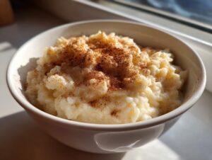 Close-up of a bowl of creamy rice pudding recipe topped generously with ground cinnamon.