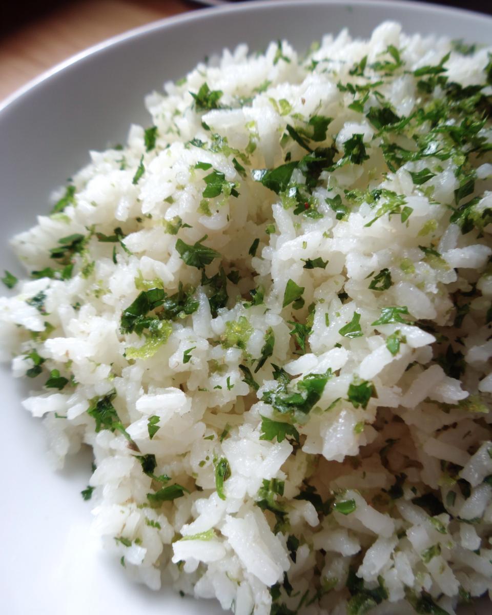 Close-up of fluffy white rice mixed generously with chopped cilantro and lime zest, creating vibrant cilantro lime rice.
