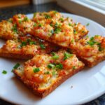 Close-up of several golden brown pieces of shrimp toast topped with minced shrimp mixture and fresh green onions.