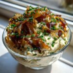Creamy homemade onion dip topped generously with caramelized onions and fresh chopped chives.