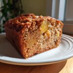 Close-up of a moist slice of hawaiian banana bread showing visible chunks of pineapple baked inside.