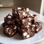 A tempting stack of homemade rocky road fudge squares loaded with marshmallows and nuts.