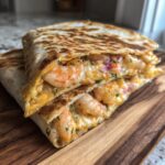 Close-up of a perfectly grilled shrimp quesadilla sliced in half, revealing melted cheese and plump shrimp.