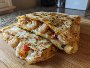 Two halves of a perfectly grilled shrimp quesadilla overflowing with melted cheese and plump shrimp.