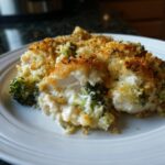 A close-up serving of creamy Chicken Divan casserole featuring chicken, broccoli, and a golden-brown breadcrumb topping.