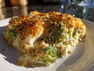 A close-up serving of creamy Chicken Divan casserole with bright green broccoli florets and a crispy, golden breadcrumb topping.