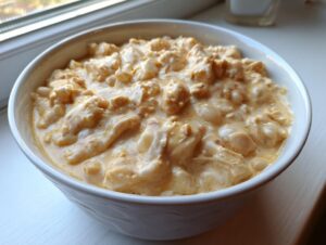 Close-up of a creamy bowl of crockpot white chicken chili featuring shredded chicken and white beans.
