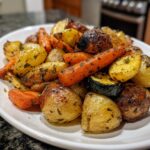 A close-up of perfectly roasted carrots, potatoes, and zucchini seasoned with herbs, showcasing delicious Garlic Herb Roasted Veggies.