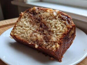 Close-up of a moist slice of apple bread showing a rich cinnamon swirl and tender crumb.