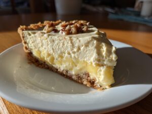 A close-up slice of rich million dollar pie featuring a graham cracker crust, creamy filling, and chopped pecans on top.