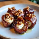 Close-up of glossy, caramelized stuffed dates filled with cream cheese and topped with walnuts.