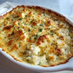 Close-up of hot, baked joes crab shack crab dip with a golden, bubbly cheese crust and parsley.
