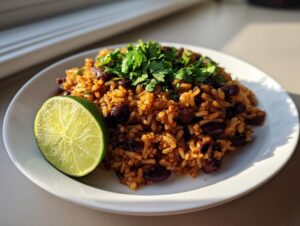 A serving of Mexican black beans and rice recipe topped with fresh cilantro and a lime wedge.